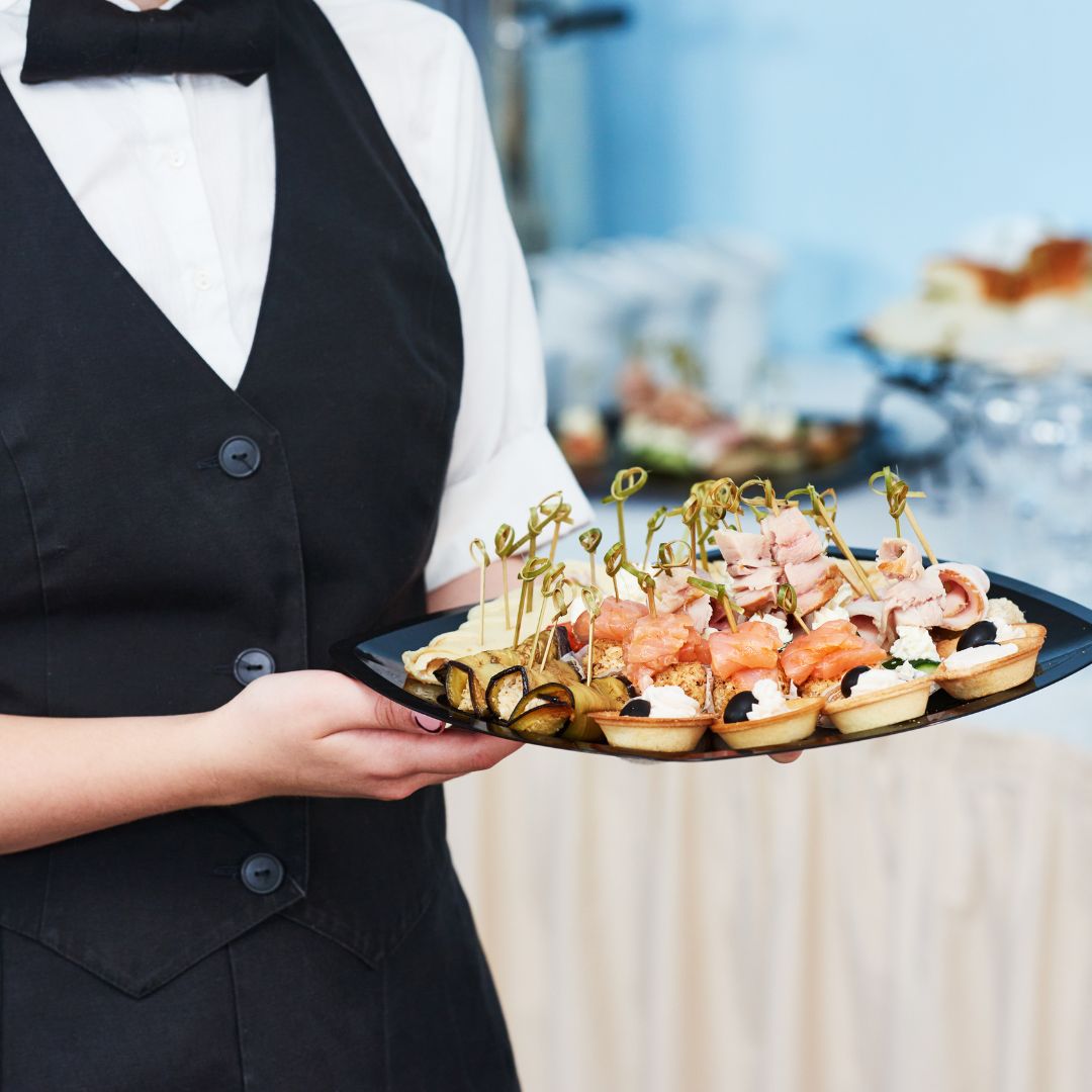 server holding a tray of appetizers